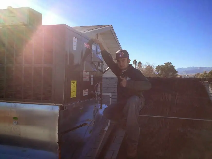 HVAC technician performing AC Tune-Up on a rooftop unit in Lexington